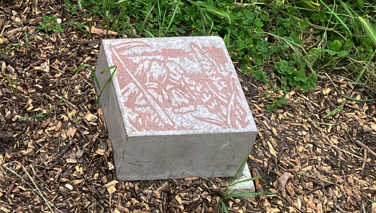 tread stone with scythe and grain illustration in graphic concrete