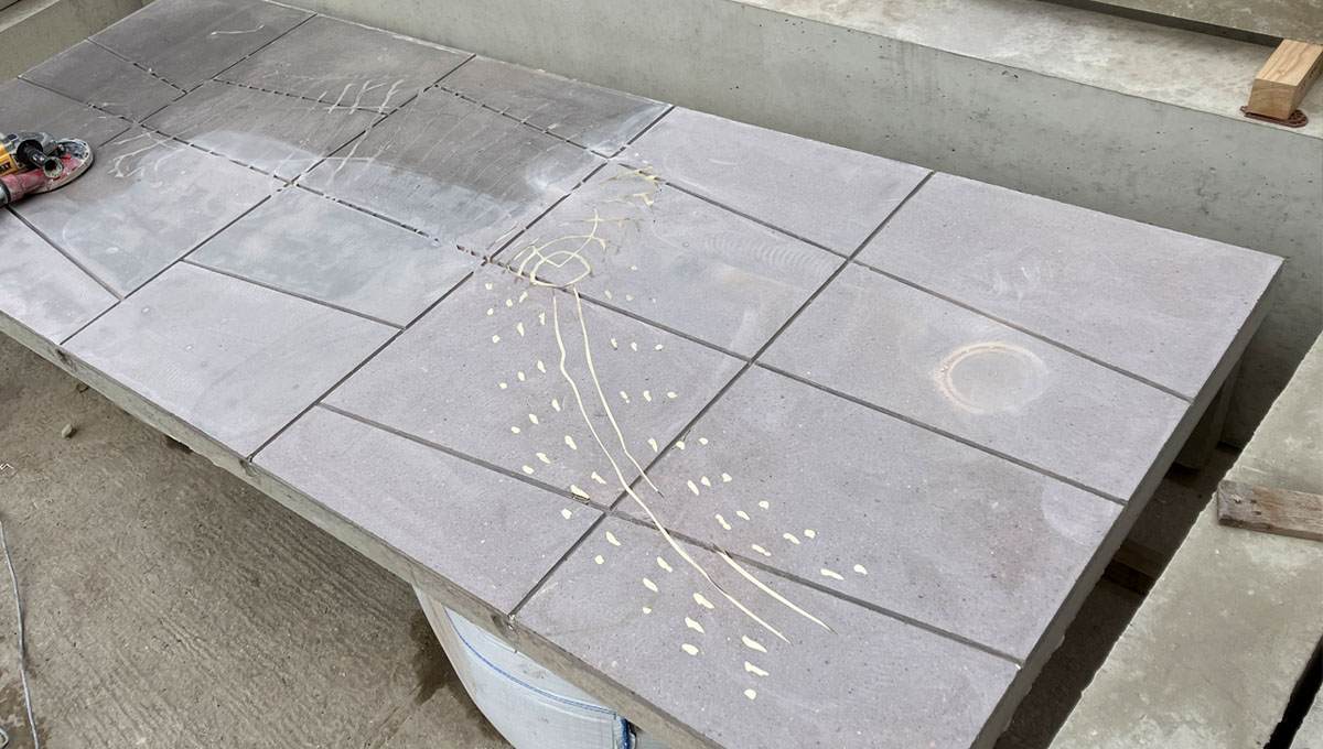 3.2 by 1.2m piece of visual precast concrete with paving slab pattern and a brass inlay of a prehistoric Millipede for the Natural history Museum, London