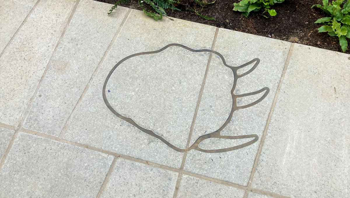 Multi-paver piece of visual precast concrete with paving slab pattern and a brass inlay of a prehistoric T-Rex footprint for the Natural history Museum, London
